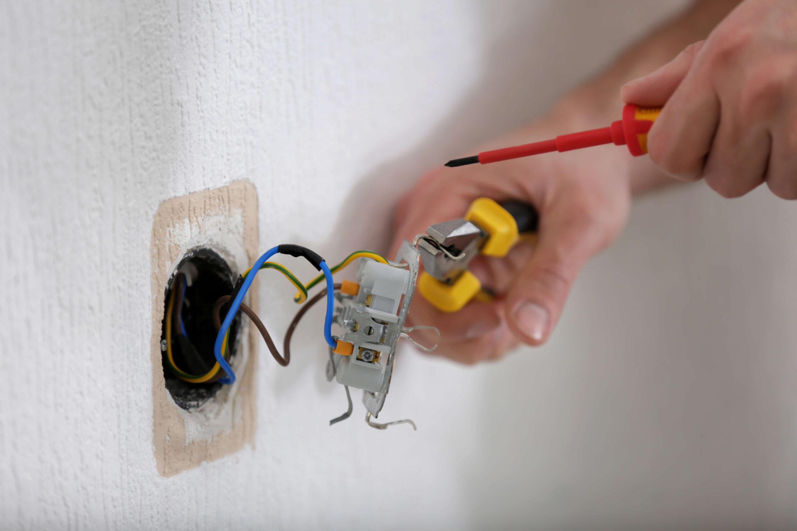hands-electrician-installing-socket-closeup